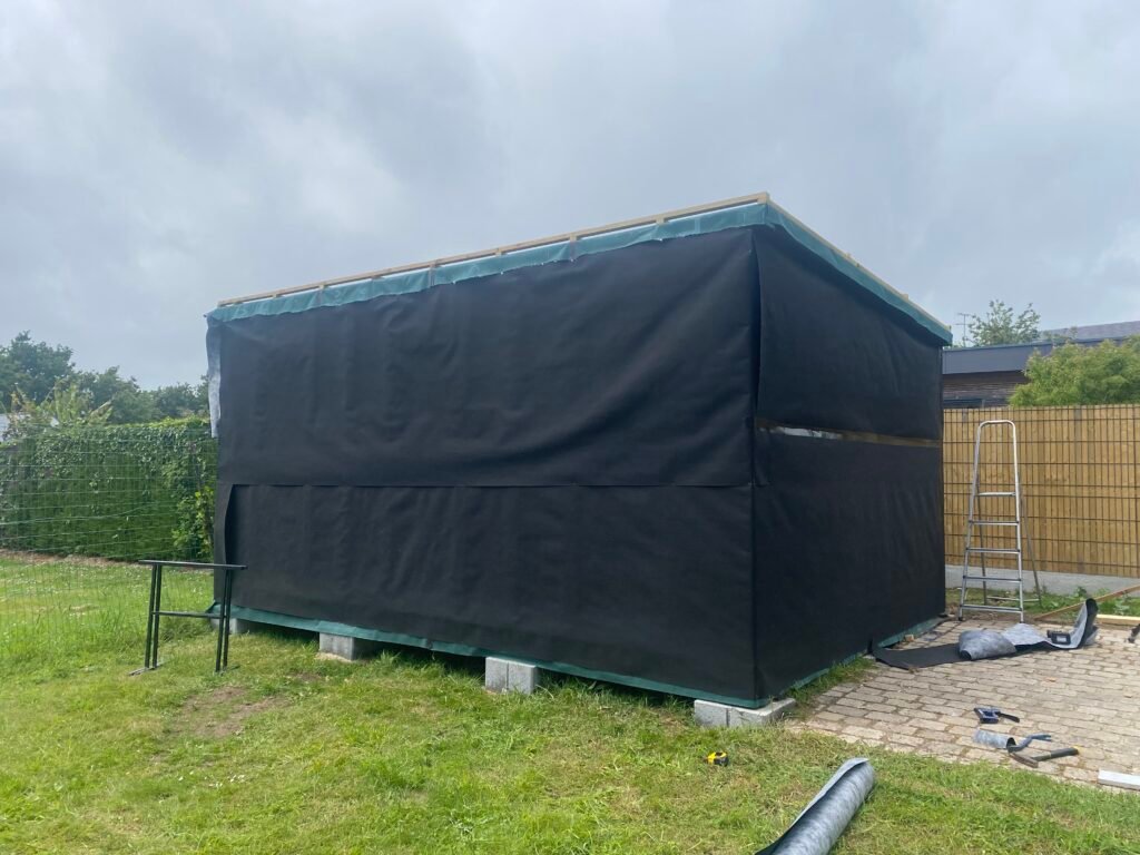 Studio habillé de son pare-pluie noir avant le bardage