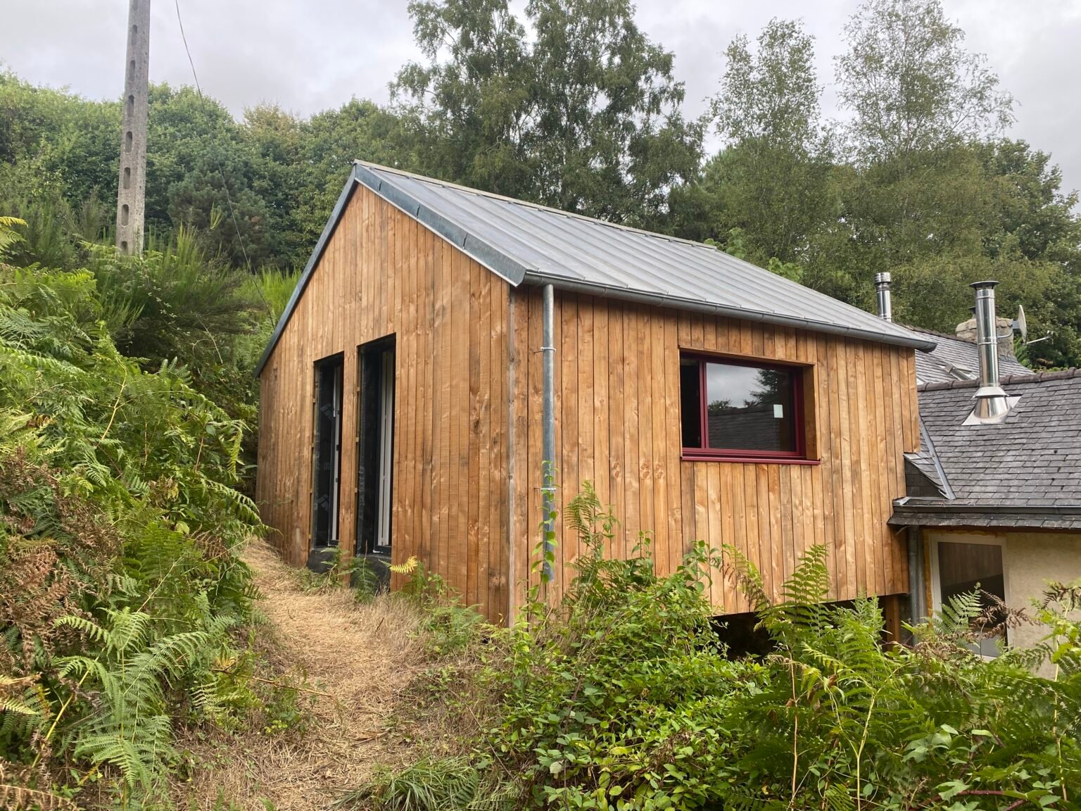 Extension en bois bardée de douglas accolée à une maison