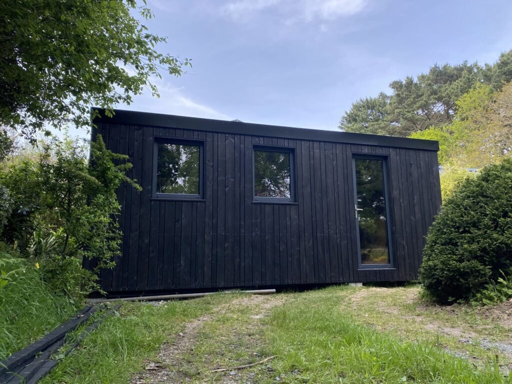 Façade du studio noir de Combrit avec ses deux fenêtres et sa porte vitrée